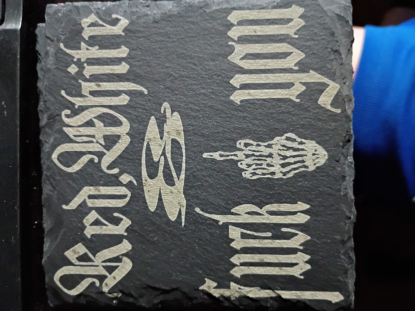 Close-up of etched slate with a bold gothic red white and design